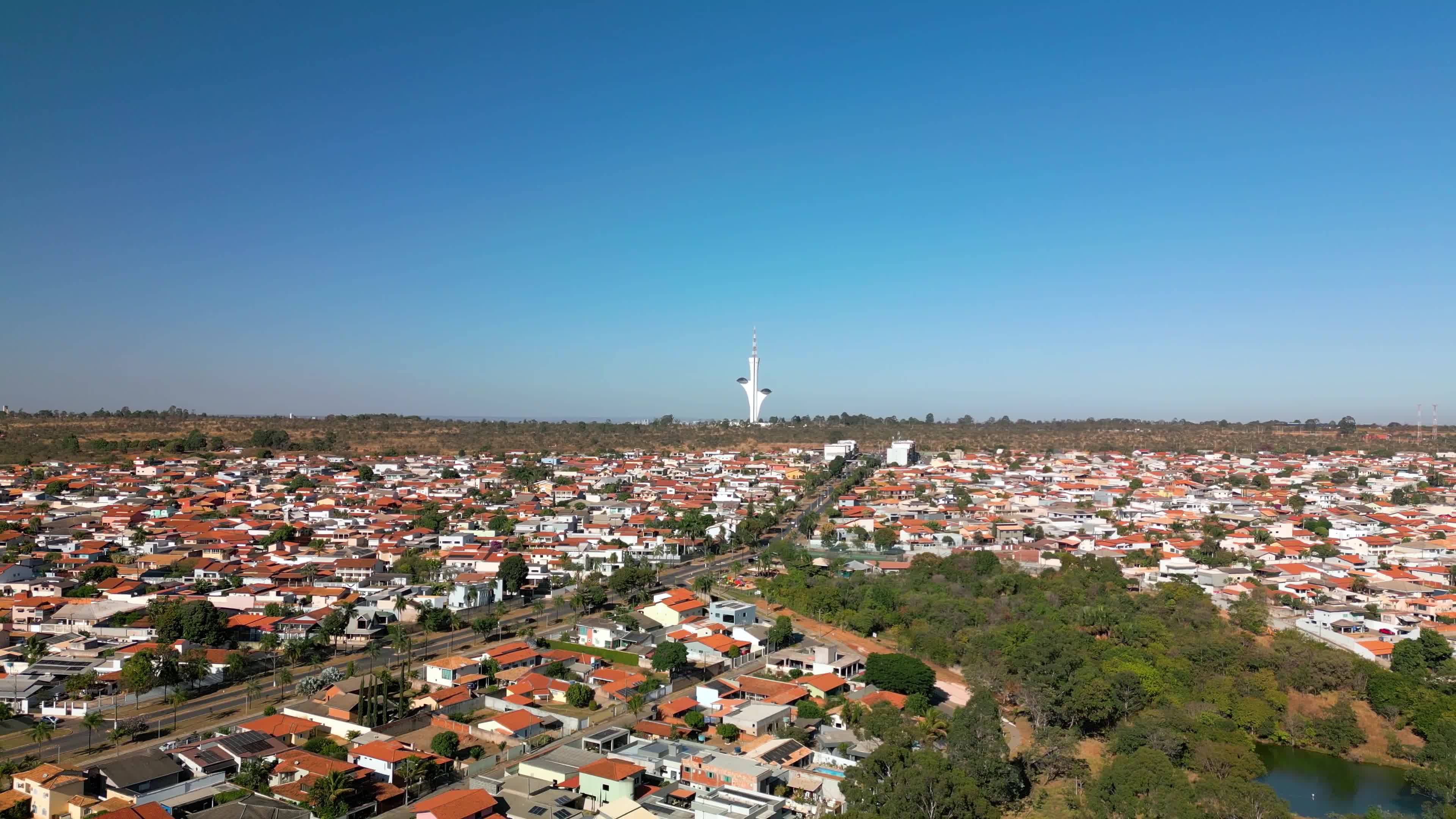 Cidade horizontal de casa com torre futurística no horizonte.