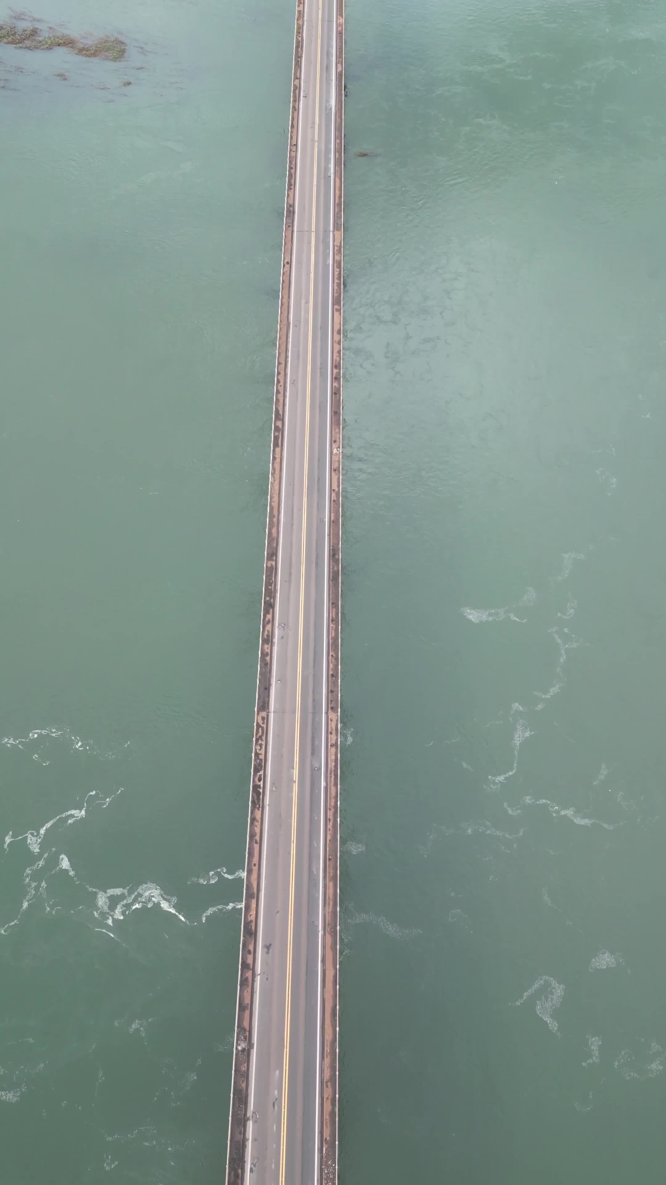 Ponte solitária sobre águas verdes