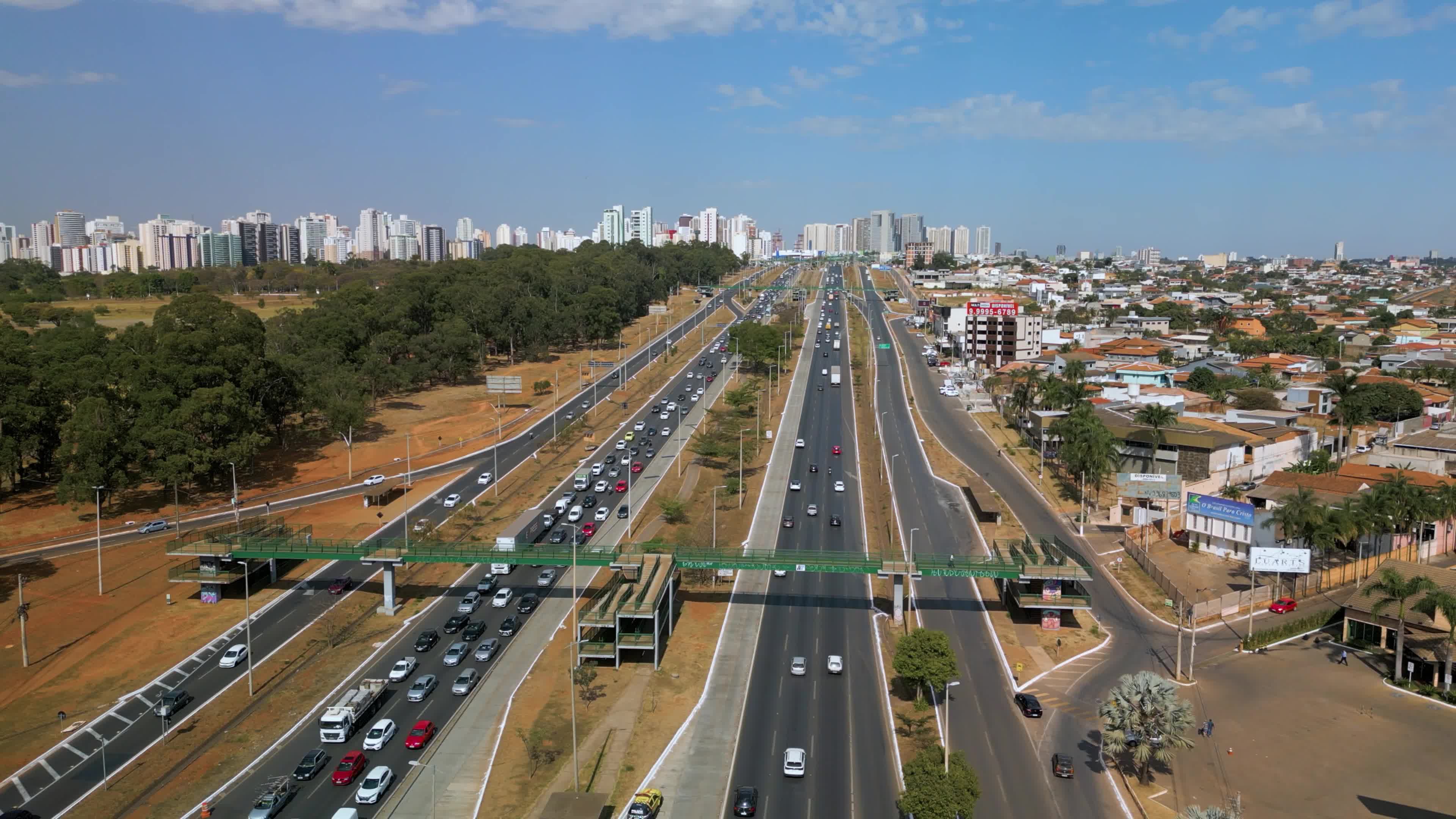 Rodovia movimentada ao lado de área verde