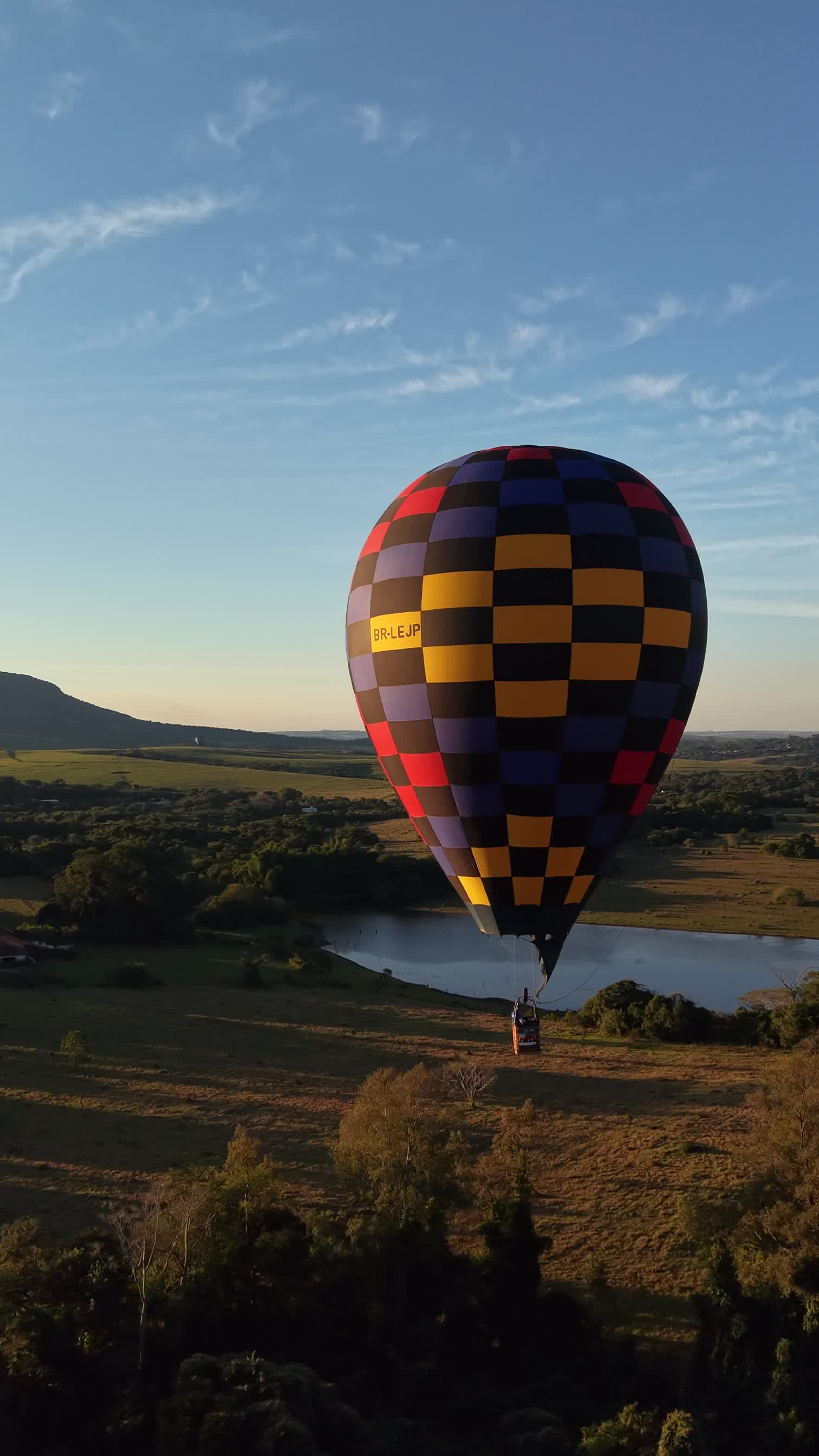 Balão colorido sobre paisagem ao entardecer